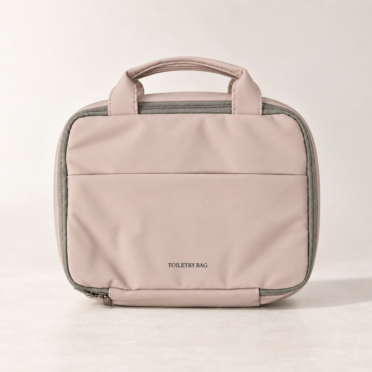 Closed dusty rose hanging toiletry bag with carry handles and front pocket