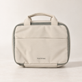Closed warm beige hanging toiletry bag with carry handles and front pocket