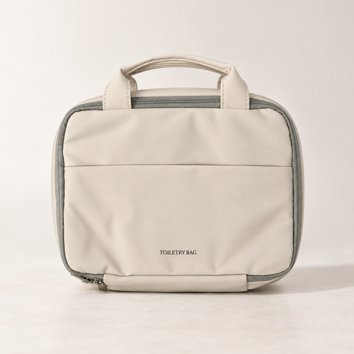 Closed warm beige hanging toiletry bag with carry handles and front pocket