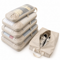 Five beige compression packing cubes stacked beside a double-sided shoe bag